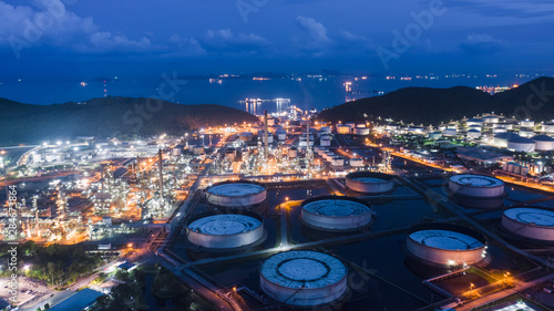 oil refinery and gas petrochemical industry with storage tanks steel pipeline area at twilight aerial view from drone