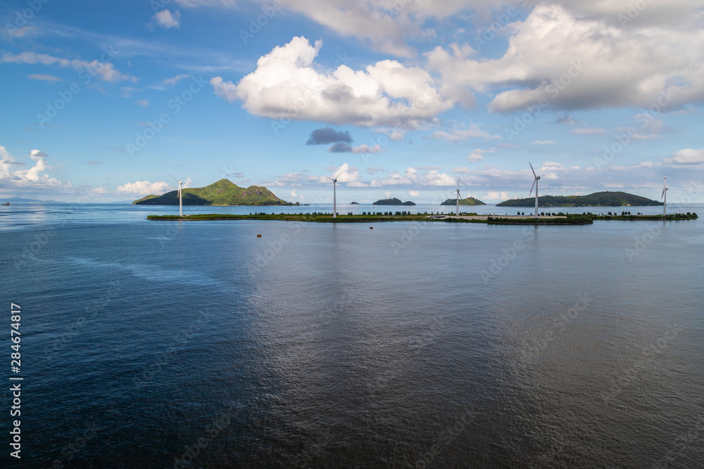 Port Victoria on Seychelles island mahé with wind wheels on an island in the background