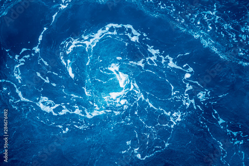 Vortex with foam in the ocean made by turning ship.