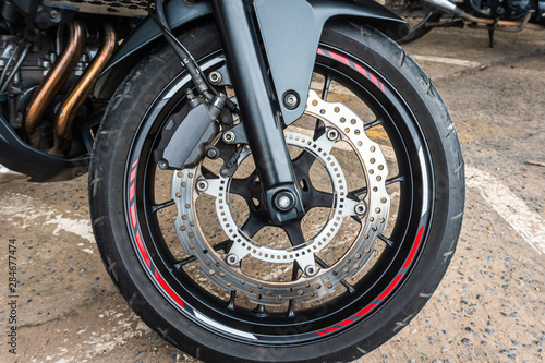 Front wheel close up of brakes system in a modern motorcycle modern with disc brakes.