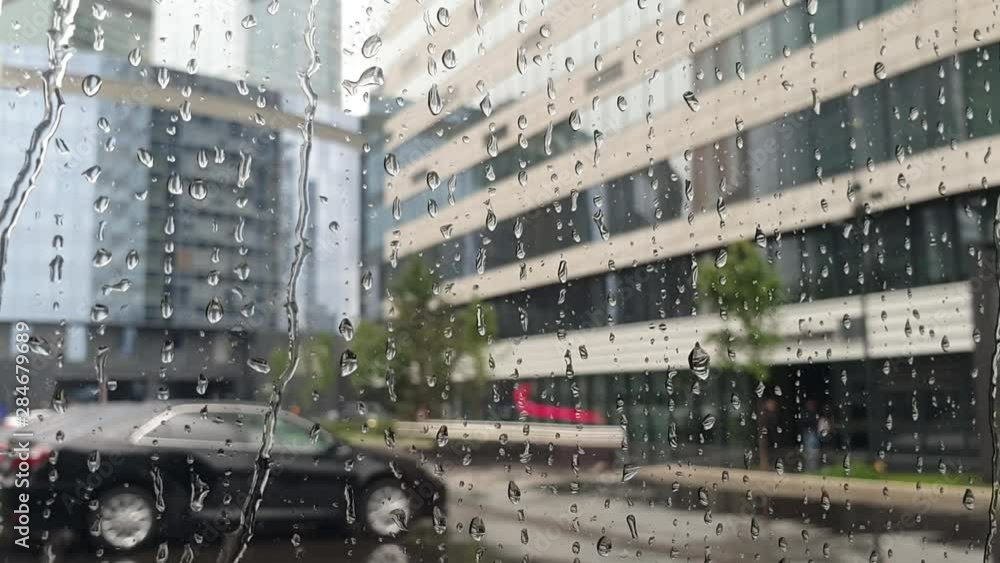 raindrops flow through the glass window. bad weather in the city. raindrops flow through the glass window. bad weather in the city.