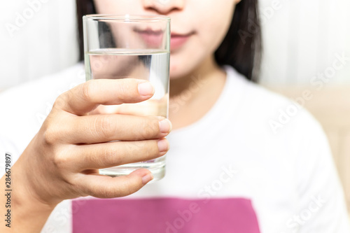 Cute asian young woman drink water from glass. Beautiful young girl hand holding drinking water.