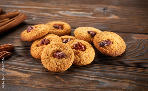 Fresh baked cookies with nuts on a dark wooden background,