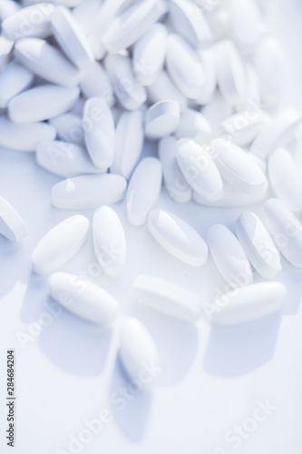 White pills heap blured background