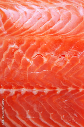 Fresh raw salmon fish textured fillet close up abstract background