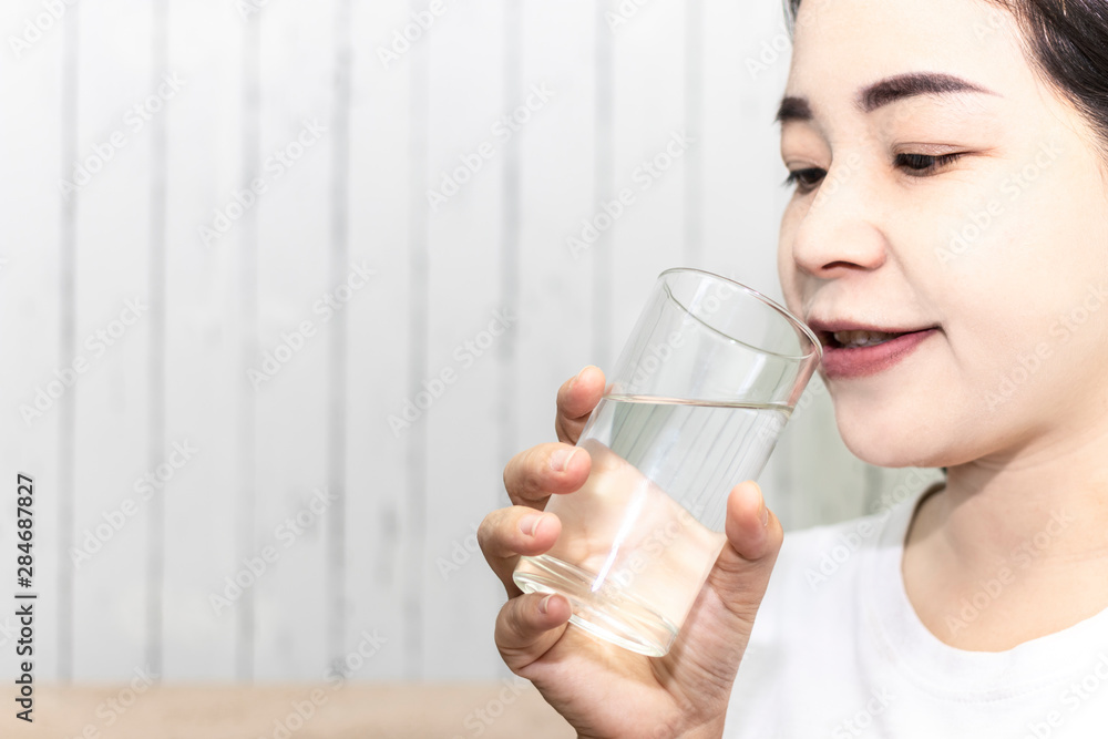 Cute asian young woman drink water from glass. Beautiful young girl hand holding drinking water. Cute asian young woman drink water from glass. Beautiful young girl hand holding drinking water.