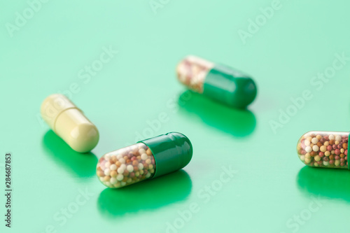 various capsules with antibiotics on a green background