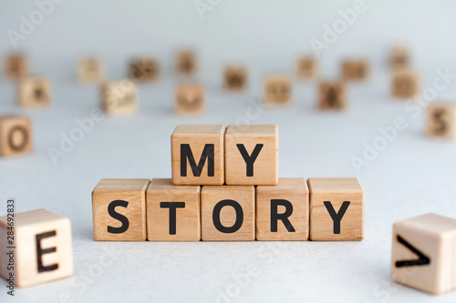 my story - words from wooden blocks with letters, my story concept story of my life, random letters around, white  background