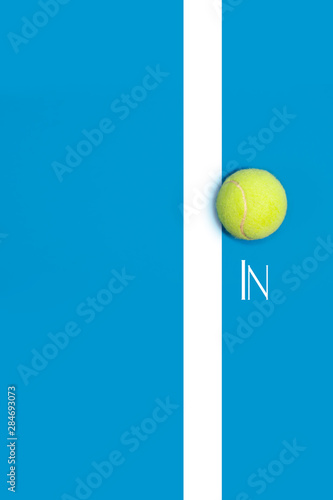 Big tennis ball on blue background In or out challenge hard court © allasimacheva