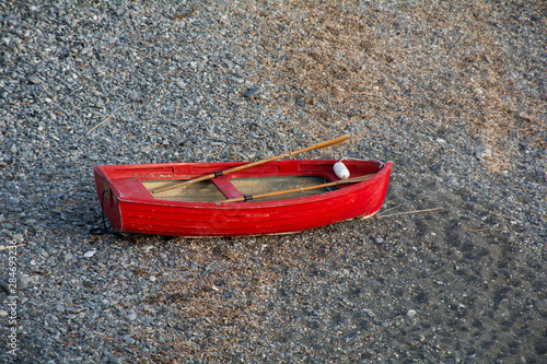 Barca di legno rossa abbandonata sulla spiaggia