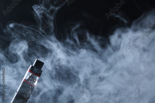 Electronic cogarette vape on a dark background with steam
