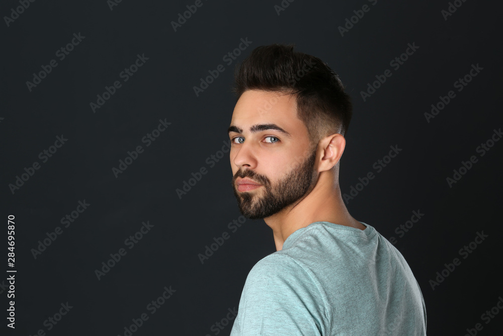 Portrait of handsome young man on black background. Space for text
