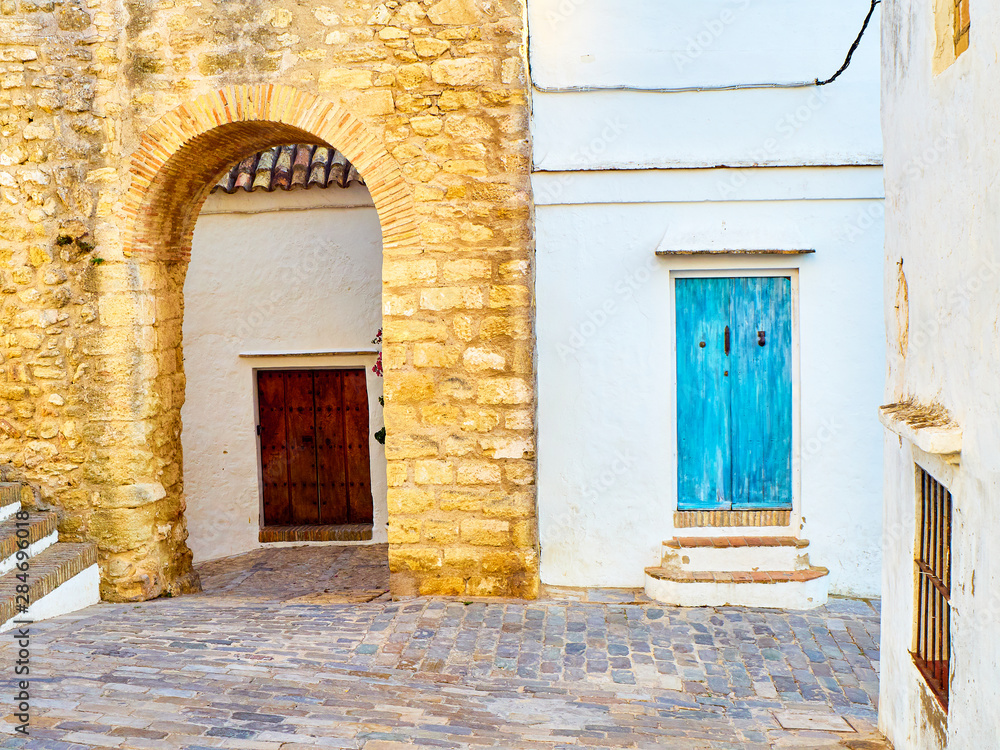 Fototapeta premium Arch of the Closed Door, Arco de la Puerta Cerrada, in the Jewish quarter of Vejer de la Frontera downtown. View from Jewry street, Calle de la Juderia. Vejer de la Frontera, Cadiz province, Andalusia