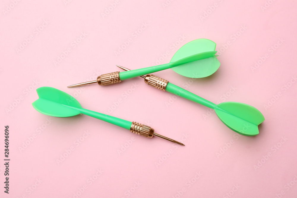 Green dart arrows on color background, flat lay Green dart arrows on color background, flat lay