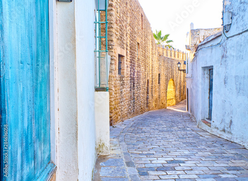 Walls of Vejer de la Frontera downtown with the Arch of the Closed Door, Arco de la Puerta Cerrada, in the background. View from Jewry street in the Jewish quarter. Vejer de la Frontera, Cadiz provinc photo