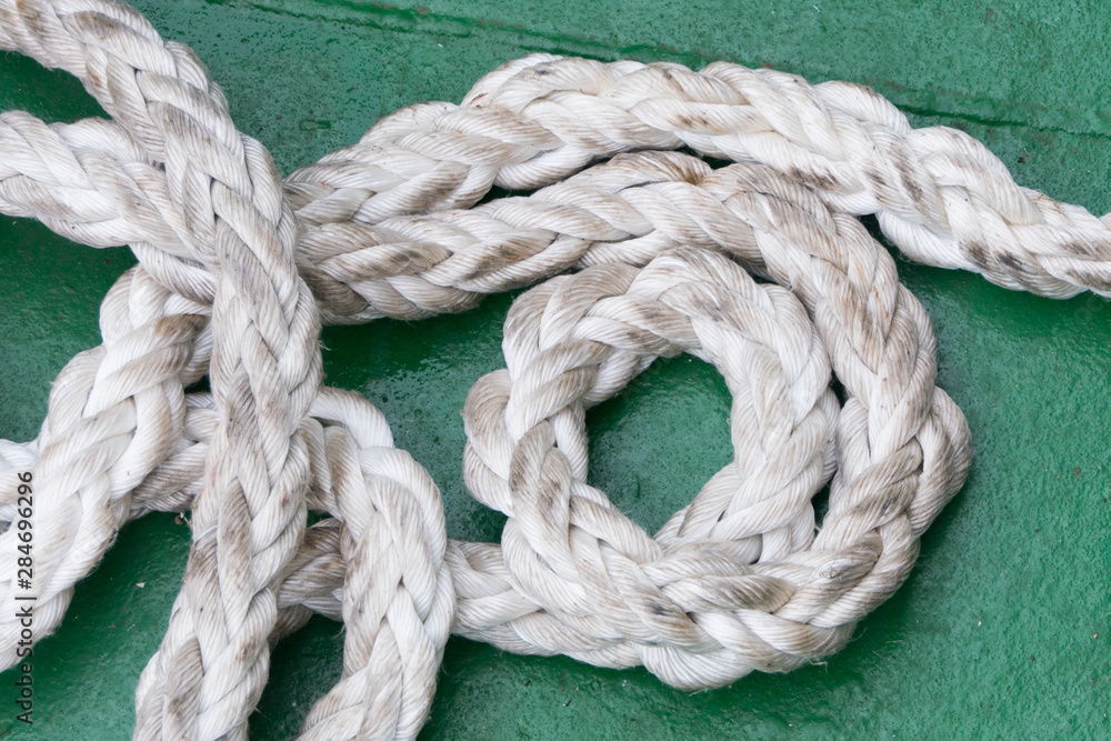 A section of ships rope lies coiled on a green floor - Image_