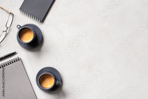 Office background with two cups of coffee espresso and open notepads