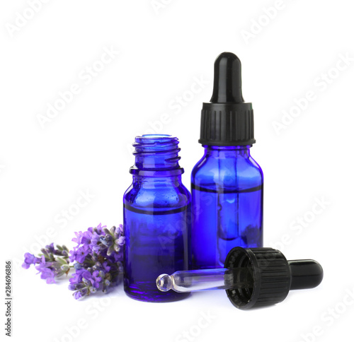 Bottles of essential oil and lavender flowers isolated on white