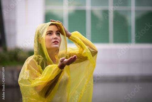 Photos Women wearing yellow raincoat while raining in rainy season