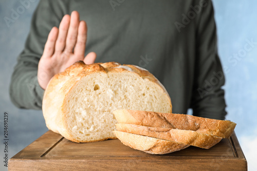 Man refusing to eat bread, closeup. Food allergy concept