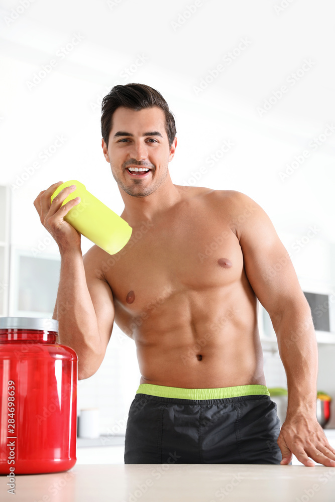 Young shirtless athletic man with protein shake powder in kitchen Young shirtless athletic man with protein shake powder in kitchen