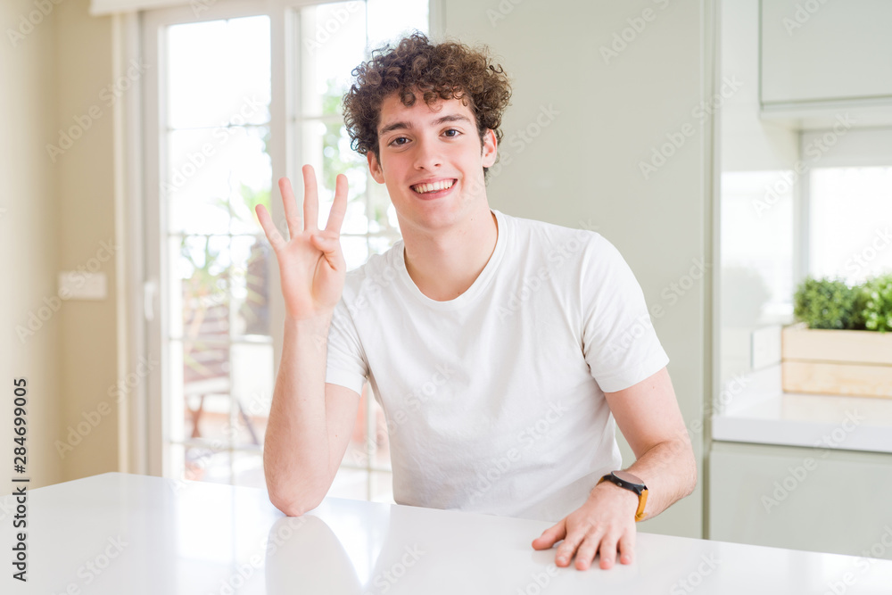 Young handsome man wearing white t-shirt at home showing and pointing up with fingers number four while smiling confident and happy. Young handsome man wearing white t-shirt at home showing and pointing up with fingers number four while smiling confident and happy.