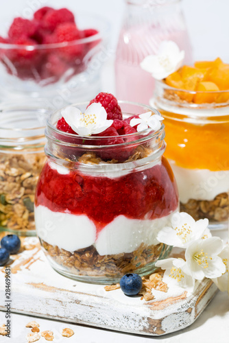 desserts with muesli, fresh berries and fruit in jars, vertical closeup