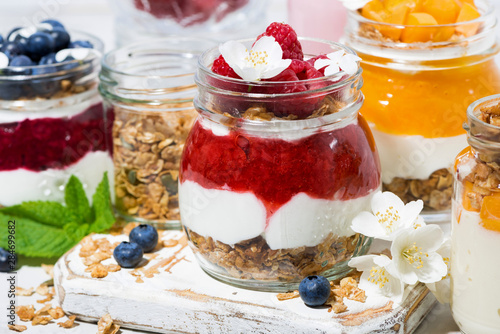 desserts with muesli, fresh berries and fruit in jars, closeup