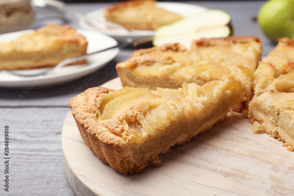 Cut delicious sweet pear tart on wooden table, closeup