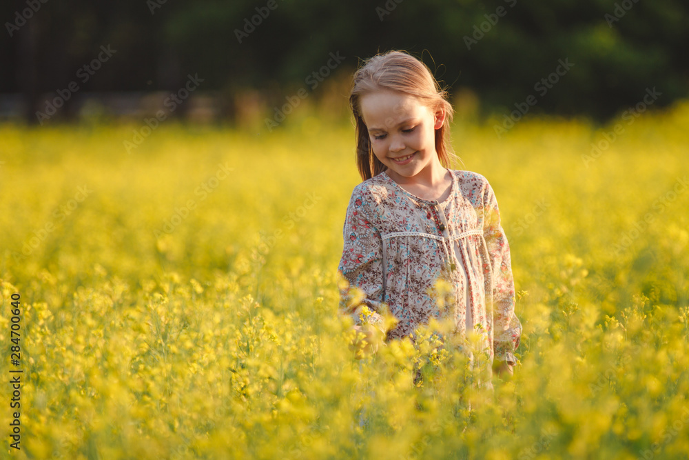 The concept of health and youth. Carefree young girl enjoys the sunset in a canola field. The concept of health and youth. Carefree young girl enjoys the sunset in a canola field.