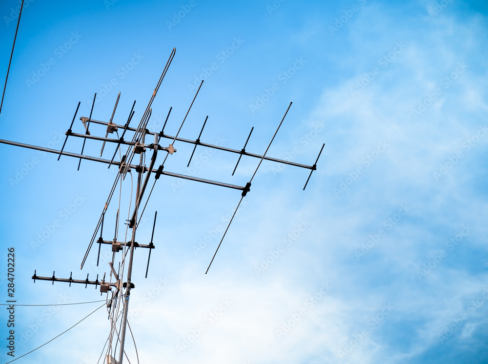 Old television antenna signal transmission on sky blue. Old technology TV communication. Old television antenna signal transmission on sky blue. Old technology TV communication.