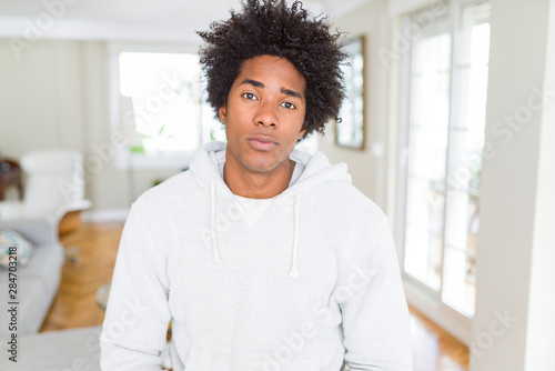African American man wearing sweatshirt with serious expression on face. Simple and natural looking at the camera.