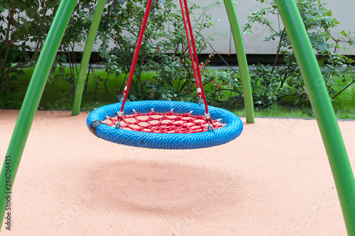 Children's playground with swings. Rope circle blue on a swing. Children's entertainment.