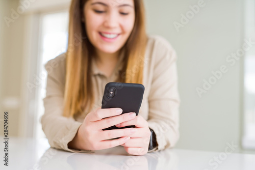 Close up of woman using smartphone and smiling confident