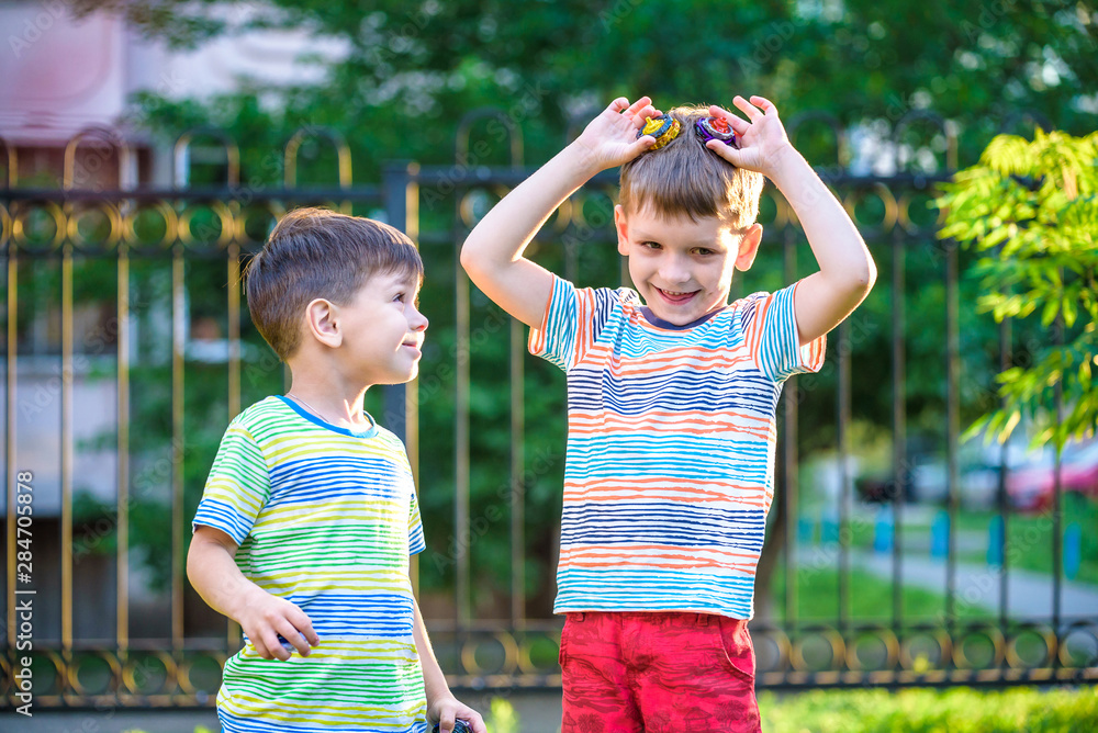 two Boy playing with a spinning top outdoors two Boy playing with a spinning top outdoors