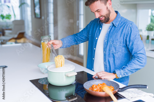 Handsome man cooking pasta at home