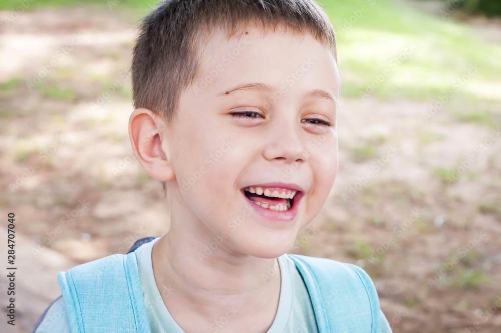 Cute Caucasian child smiling outside, summer time, day, positive mood, happy childhood concept. Cute Caucasian child smiling outside, summer time, day, positive mood, happy childhood concept.