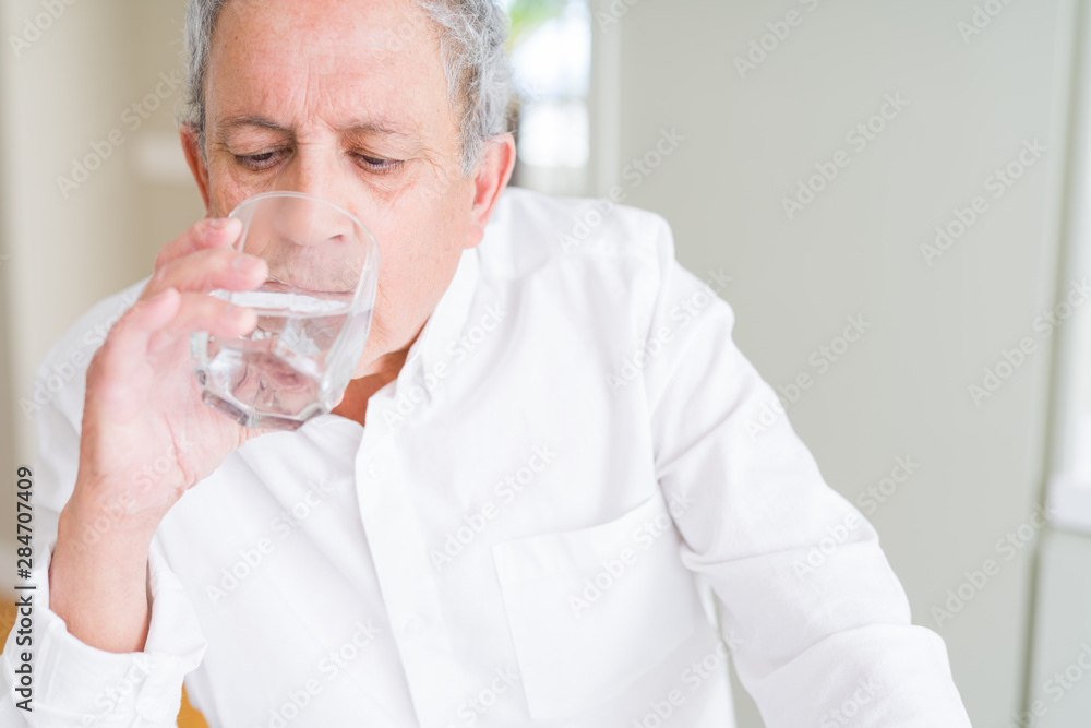 Handsome senior man drinking a fresh glass of water at home Handsome senior man drinking a fresh glass of water at home