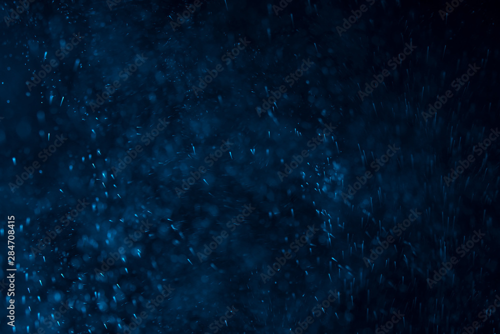 splashes of water or snow on a dark background with a blue tint