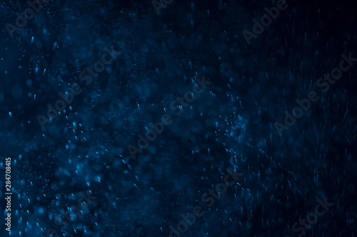 splashes of water or snow on a dark background with a blue tint © Владимир Солдатов