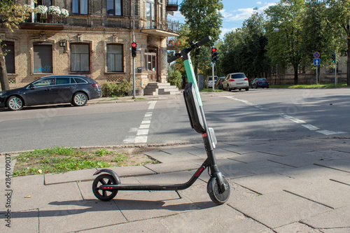 An electric scooter is parked at a crossroads in the city center.