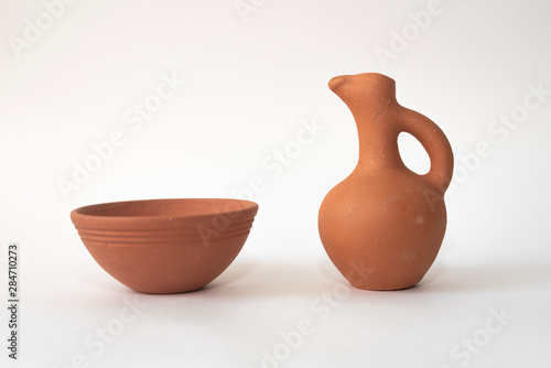 A traditional handmade Georgian wine jug and clay cup for a red wine or water on white isolated background photo