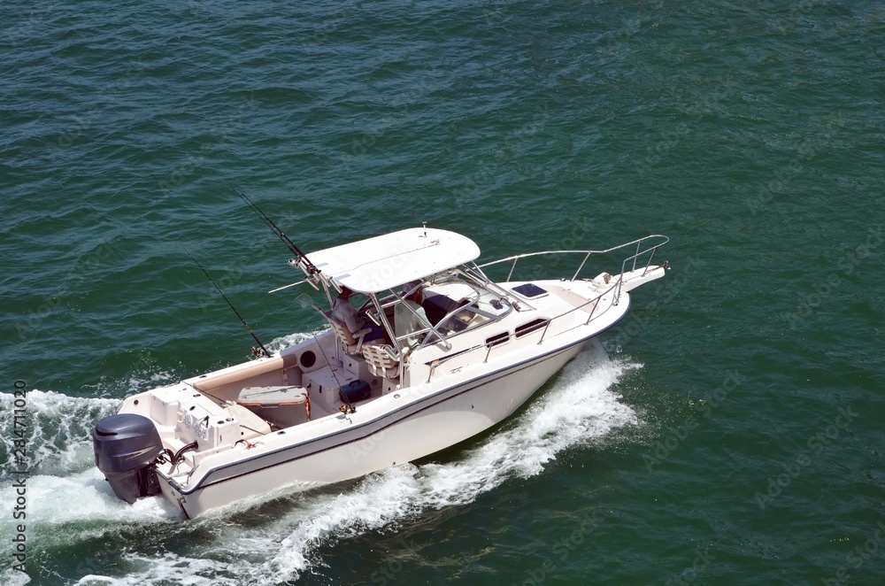 Angled overhead view of a small white sport fishing boat powered by one  outboard engine Stock Photo
