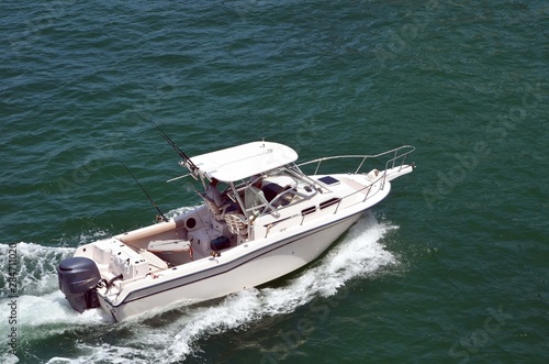 Angled overhead view of a small white sport fishing boat powered by one outboard engine