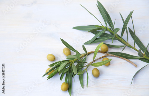 Flat lay. Olive branch with leaves with green olives on a blue background. Healthy food Mediterranean diet. Pattern, background, texture. With copy space Top view. Abstract background .
