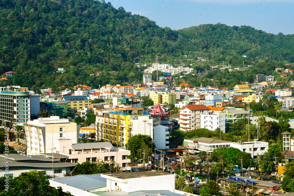 Aerial view of Patong beach, Phuket island and mountains, urban city with blue sky. Andaman sea, Thailand.