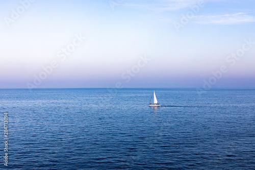 Lonely sailboat sailing at sunset on the Mediterranean © Victor