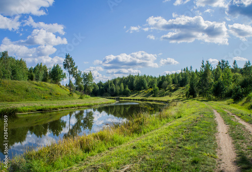 Beautiful summer landscape with a river and green grass.