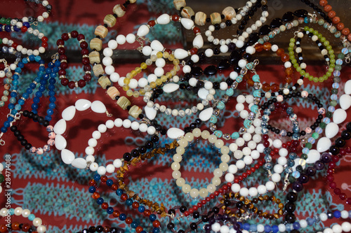 разноцветные ожерелье из оникса лежат на торговом прилавке. Концепт - производство изделий из оникса. Полудрагоценные камни