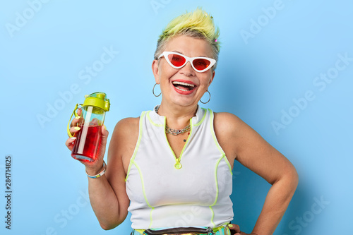 rock fan holding red beverage and posing to the camera, pleasure and subculture concept.magic drink